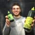 Person holding two bottles of Grazia extra virgin olive oil, one large and one small, both with green labels. - Olive Oil Times