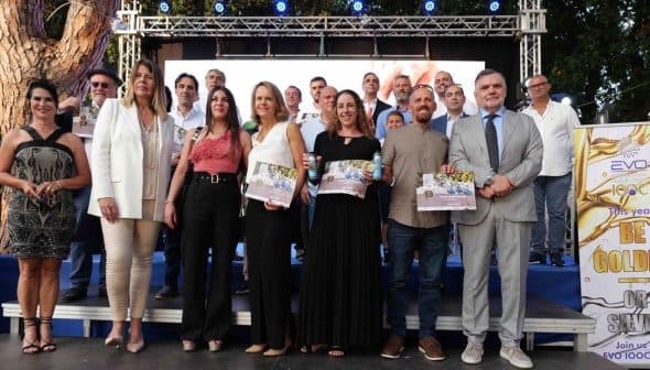 Group of people posing together at an award ceremony with certificates in hand. - Olive Oil Times