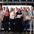 Group of people posing together at an award ceremony with certificates in hand. - Olive Oil Times