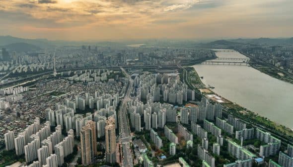 Aerial view of Seoul showing high-rise buildings and the Han River at sunset. - Olive Oil Times