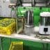 Table displaying olive oil extraction equipment alongside baskets of olives. - Olive Oil Times