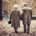 An elderly couple holding hands while walking through a park covered in autumn leaves. - Olive Oil Times