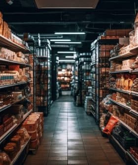 A grocery store aisle lined with shelves filled with various packaged food products and condiments. - Olive Oil Times