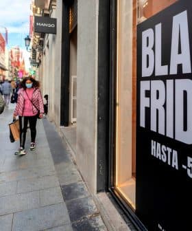 Large sign displaying 'Black Friday' with discount information on a city street. - Olive Oil Times