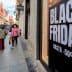 Large sign displaying 'Black Friday' with discount information on a city street. - Olive Oil Times