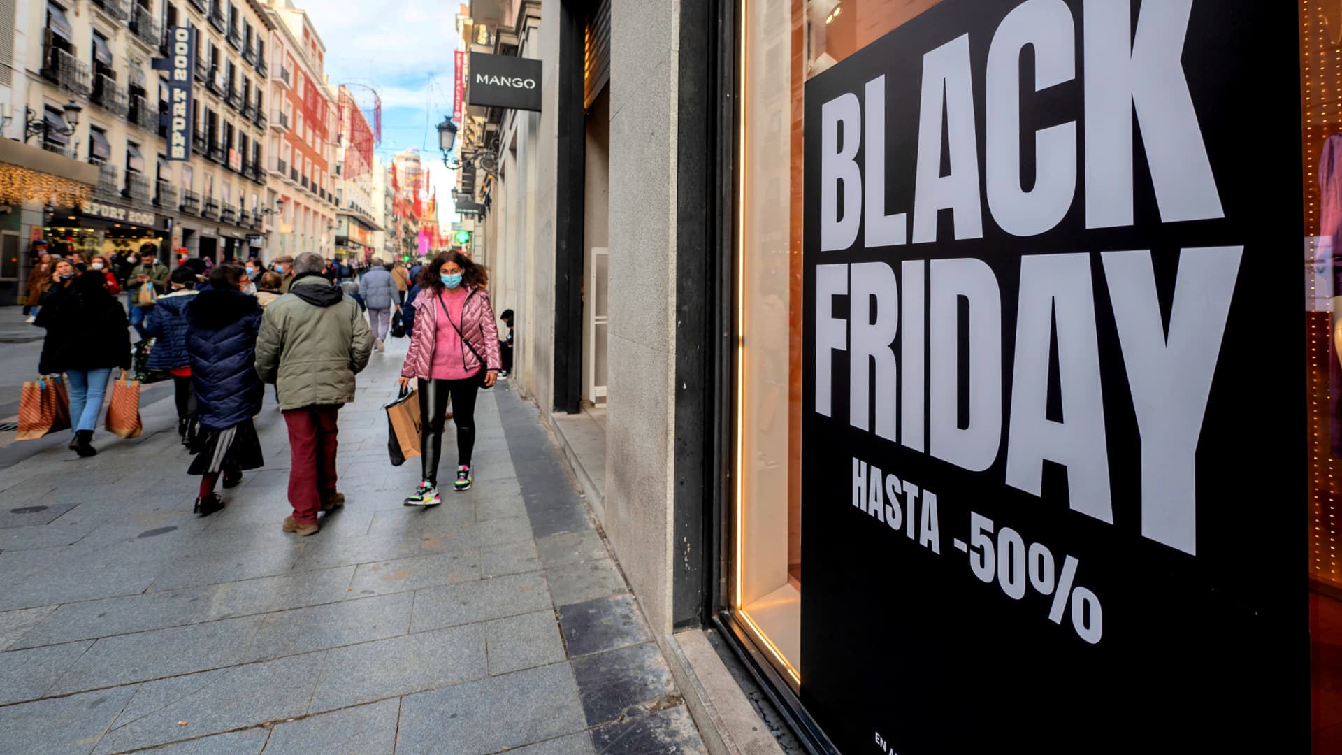 Large sign displaying 'Black Friday' with discount information on a city street. - Olive Oil Times