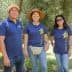 Five individuals wearing matching shirts standing together at an olive center. - Olive Oil Times