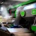 Industrial olive oil processing machine with green accents and steam emerging from the equipment. - Olive Oil Times