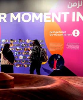 Colorful exhibition display featuring the phrase 'Our Moment in Time' and various images on the wall. - Olive Oil Times