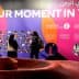 Colorful exhibition display featuring the phrase 'Our Moment in Time' and various images on the wall. - Olive Oil Times