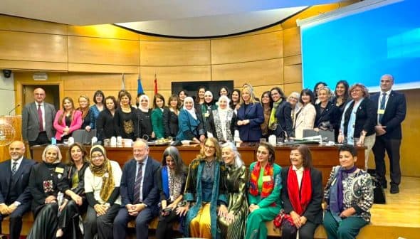 A group of women and men posing for a photo at a conference event in a formal setting. - Olive Oil Times