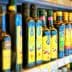 Various bottles of olive oil displayed on a shelf in a grocery store. - Olive Oil Times