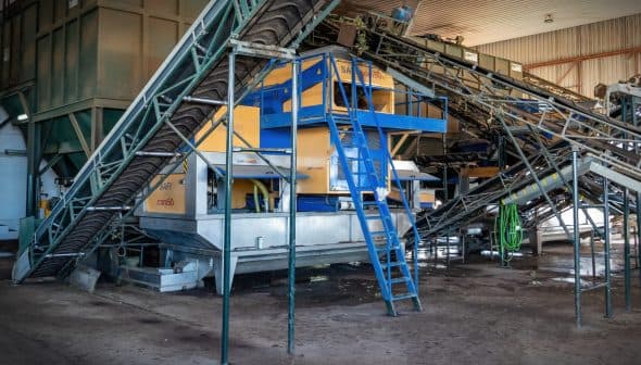 Industrial machinery used for processing olives in an olive oil production facility. - Olive Oil Times