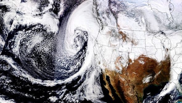 Satellite image showing a weather system swirling off the west coast of North America with cloud formations. - Olive Oil Times