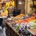 Vibrant display of various fruits and vegetables in a market setting with carts and crates. - Olive Oil Times
