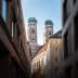 View of the twin towers of Munich's Cathedral framed by surrounding buildings. - Olive Oil Times