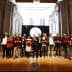 Group of individuals holding awards on stage during a ceremony in a historical building. - Olive Oil Times