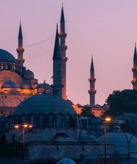 A view of a mosque in Istanbul with multiple minarets during dusk, illuminated by soft lighting. - Olive Oil Times