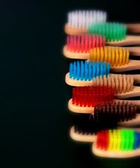 A row of bamboo toothbrushes with various colored bristles arranged in a line. - Olive Oil Times
