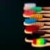 A row of bamboo toothbrushes with various colored bristles arranged in a line. - Olive Oil Times