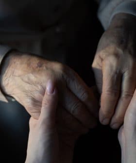 An elderly person's hand holding a younger person's hand, showcasing a connection between generations. - Olive Oil Times