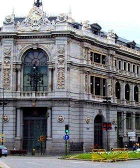 A large historic building in Madrid featuring ornate architectural details and a clock on the facade. - Olive Oil Times