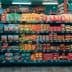A grocery store aisle displaying various packaged food items on shelves. - Olive Oil Times