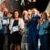 Group of people at an award ceremony, some holding certificates and applauding. - Olive Oil Times