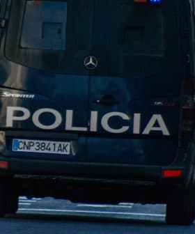 Rear view of a police van with the word 'Policia' on the back, driving on a city street. - Olive Oil Times