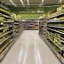 A supermarket aisle lined with shelves of olive oil bottles in various sizes and packaging. - Olive Oil Times