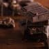 Several pieces of dark chocolate stacked on a wooden surface with additional chocolate fragments scattered around. - Olive Oil Times
