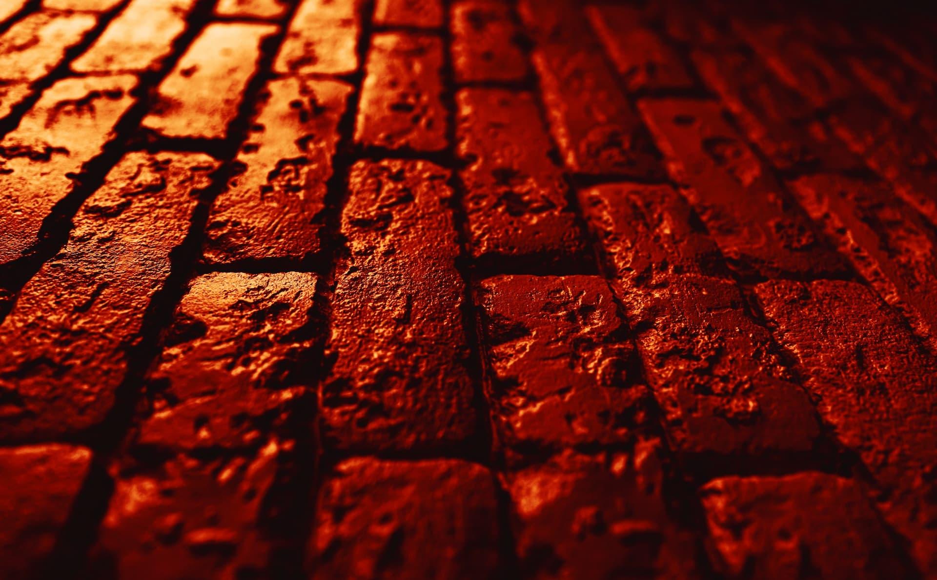 Close-up view of a textured red brick surface with visible imperfections and patterns. - Olive Oil Times