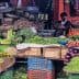 A variety of fresh vegetables displayed in baskets at a market, with a vendor seated nearby. - Olive Oil Times
