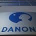 Danone company logo displayed on a building facade with a blue silhouette of a child's profile. - Olive Oil Times