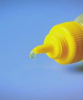 Yellow plastic mustard bottle with a yellow cap and a small drop of mustard at the tip. - Olive Oil Times