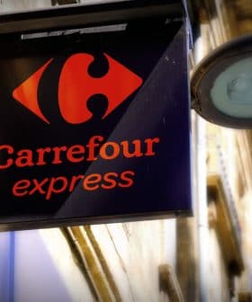Sign for Carrefour Express featuring a red logo and the name in orange text on a black background. - Olive Oil Times