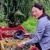 Woman sorting olives in red and yellow baskets in an outdoor setting. - Olive Oil Times