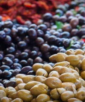 A display of green and black olives arranged in a market setting. - Olive Oil Times