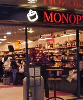 Entrance of a Monop' grocery store featuring shelves stocked with various products. - Olive Oil Times
