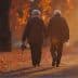 An elderly couple, dressed in warm coats, walks hand in hand down a path covered with autumn leaves. The sun sets in the background, casting a warm, golden light over the scene. The woman holds a small handbag.