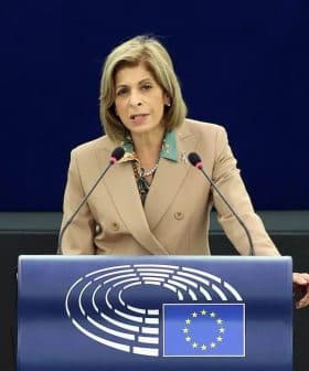 A woman speaking at a podium with the European Parliament logo during a session. - Olive Oil Times